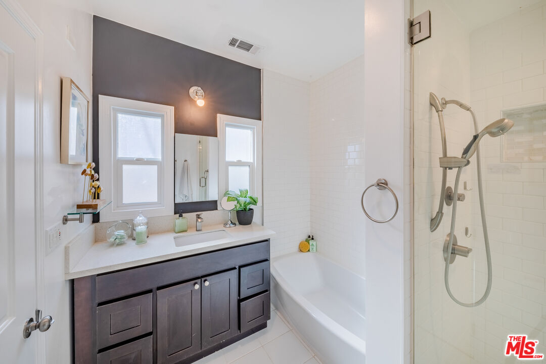 1251 South Muirfield Road Los Angeles, CA 90019 - Photo 12 of 24 a bathroom with a sink vanity and mirror