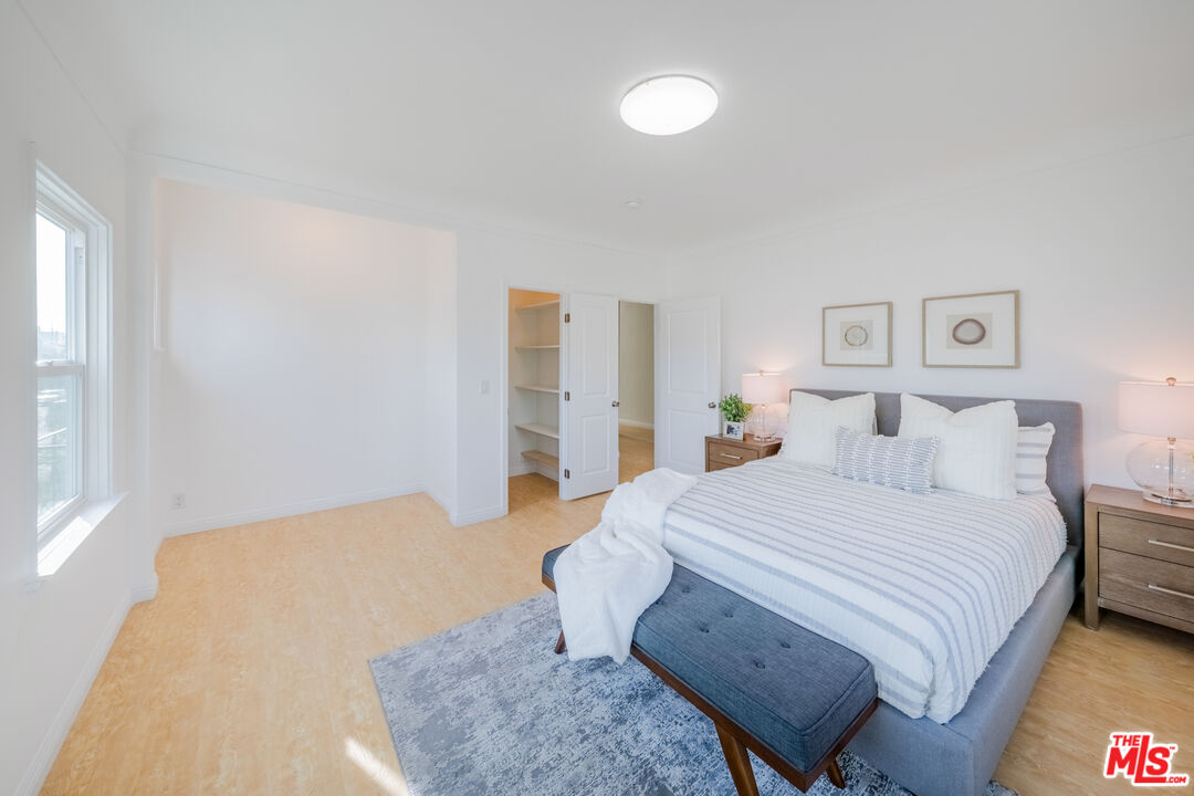 1251 South Muirfield Road Los Angeles, CA 90019 - Photo 13 of 24 a spacious bedroom with a bed and a cabinets