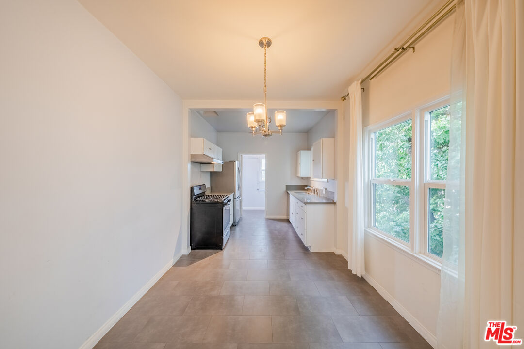 1251 South Muirfield Road Los Angeles, CA 90019 - Photo 18 of 24 a view of a kitchen with a stove wooden floor and a window