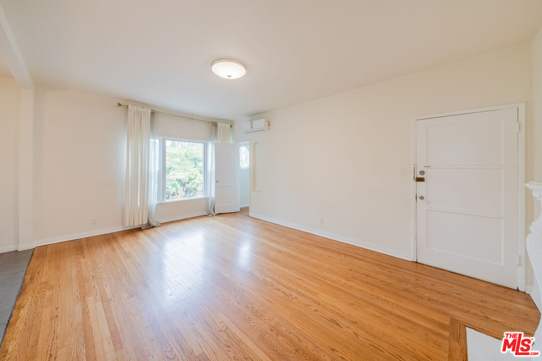 1251 South Muirfield Road Los Angeles, CA 90019 - Photo 19 of 24 an empty room with wooden floor and windows
