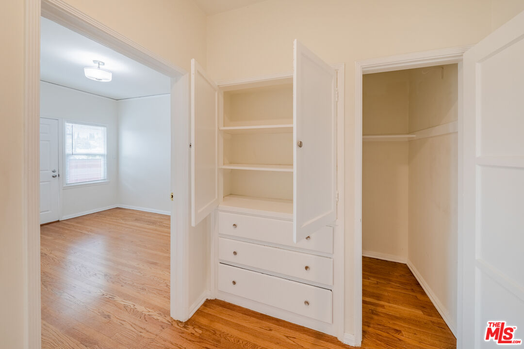 1251 South Muirfield Road Los Angeles, CA 90019 - Photo 20 of 24 a view of walk in closet with wooden floor