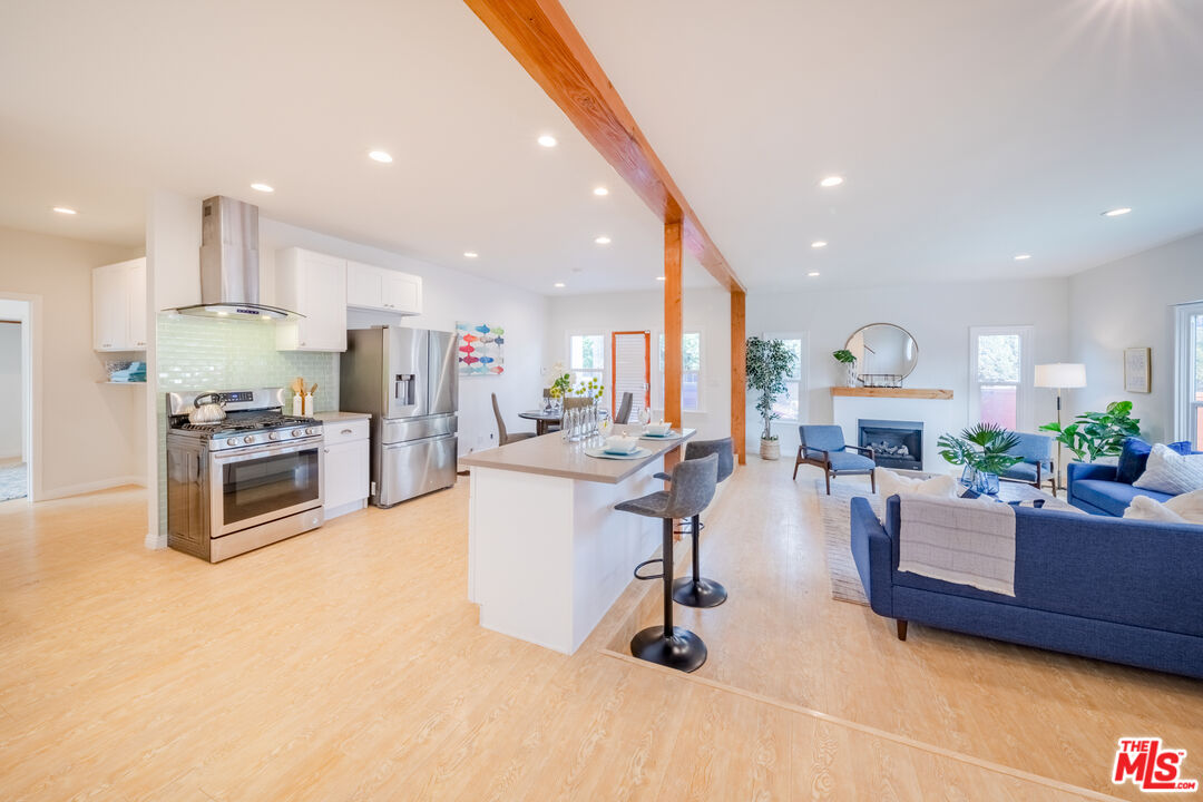 1251 South Muirfield Road Los Angeles, CA 90019 - Photo 3 of 24 a living room with furniture kitchen view and a large window