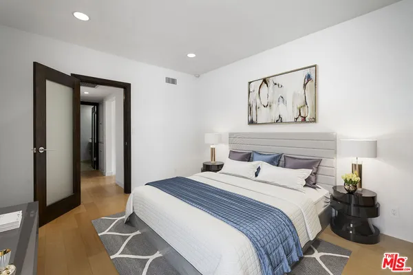a bedroom with a bed and a painting on the wall