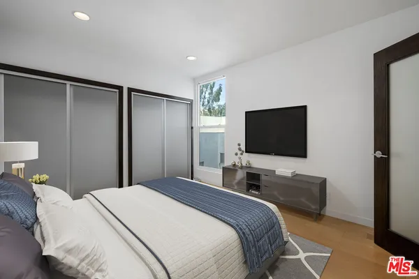 a bedroom with a bed and a flat screen tv