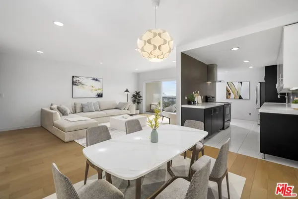 a living room with furniture a dining table and kitchen view
