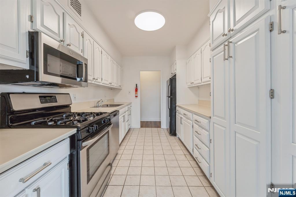 6 Horizon Road, Unit 310 Fort Lee, NJ 07024 - Photo 17 of 35 a kitchen with stainless steel appliances a stove top oven a sink and a refrigerator