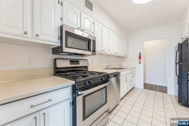 a kitchen with granite countertop a sink stove and cabinets