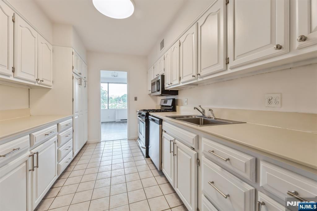 6 Horizon Road, Unit 310 Fort Lee, NJ 07024 - Photo 19 of 35 a kitchen with granite countertop a sink stove and cabinets