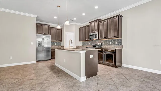 a kitchen with stainless steel appliances granite countertop a stove a sink dishwasher a refrigerator and a oven with wooden floor
