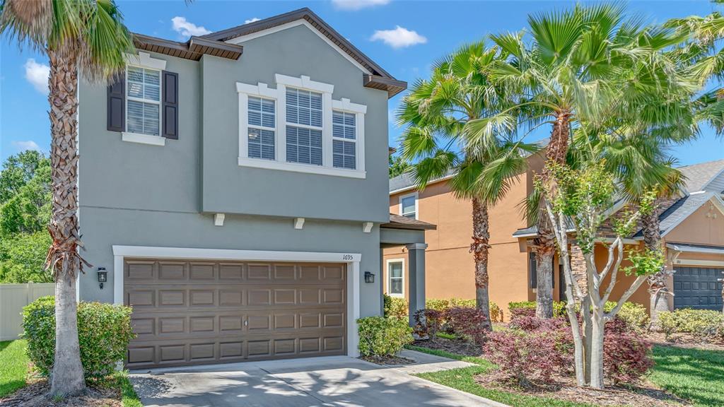 1695 Ludington Avenue Wesley Chapel, FL 33543 - Photo 2 of 65 a front view of a house with a garden