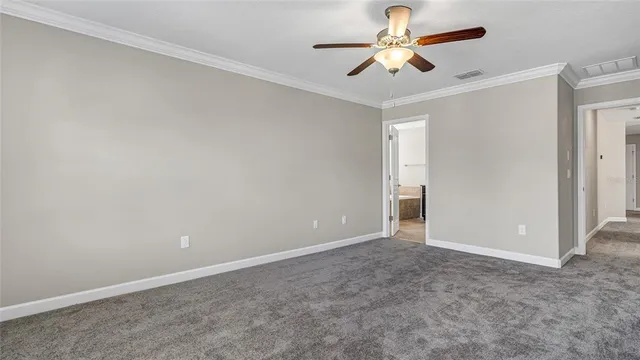 an empty room with windows and ceiling fan