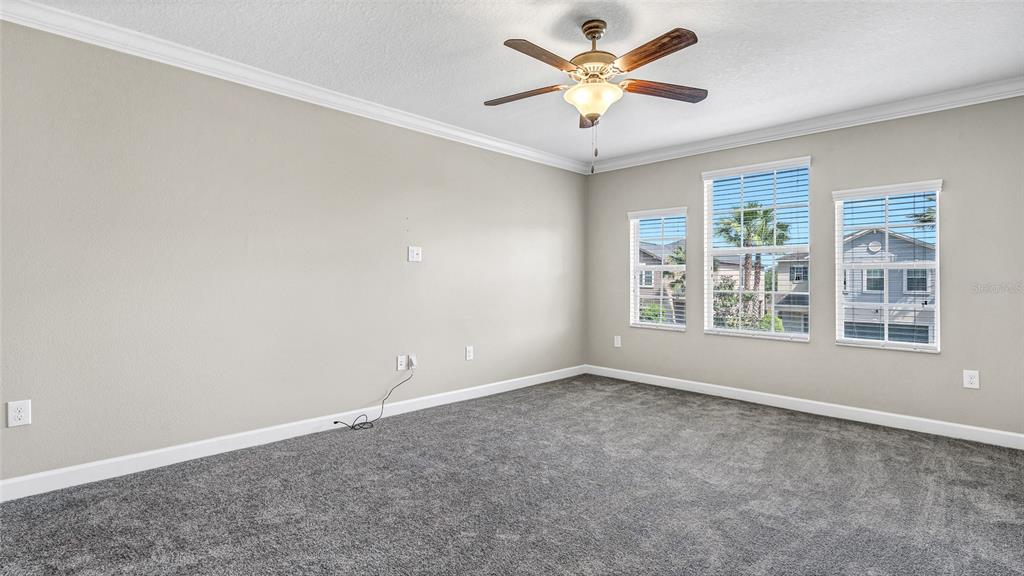 1695 Ludington Avenue Wesley Chapel, FL 33543 - Photo 32 of 65 an empty room with windows and ceiling fan