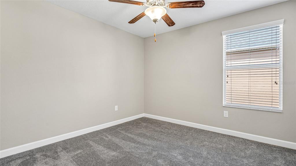 1695 Ludington Avenue Wesley Chapel, FL 33543 - Photo 33 of 65 an empty room with a window and a fan