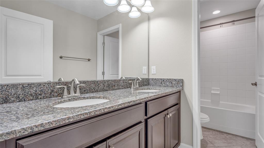 1695 Ludington Avenue Wesley Chapel, FL 33543 - Photo 37 of 65 a bathroom with a granite countertop sink and a mirror