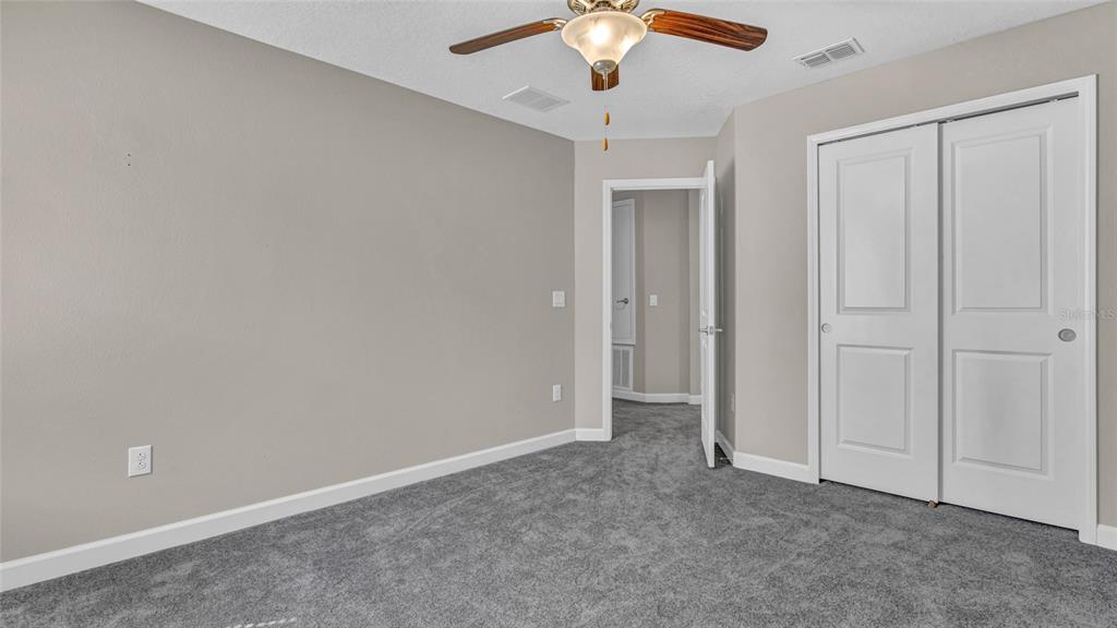 1695 Ludington Avenue Wesley Chapel, FL 33543 - Photo 39 of 65 an empty room with a chandelier fan