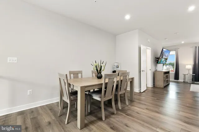 a kitchen with stainless steel appliances a refrigerator a stove a dining table and chairs