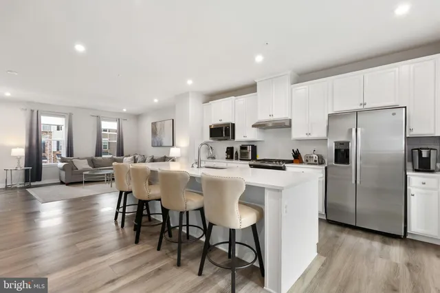 a large kitchen with kitchen island a sink table and chairs