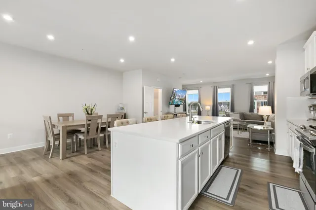 a kitchen with kitchen island stainless steel appliances a sink stove and cabinets