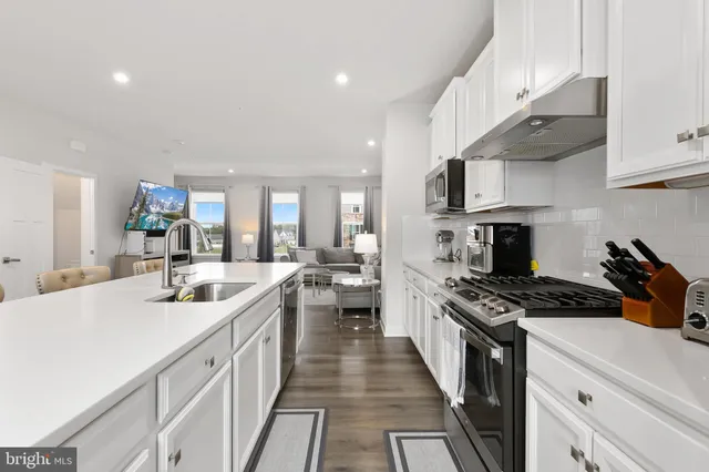 a kitchen with stainless steel appliances granite countertop a stove and a white cabinets