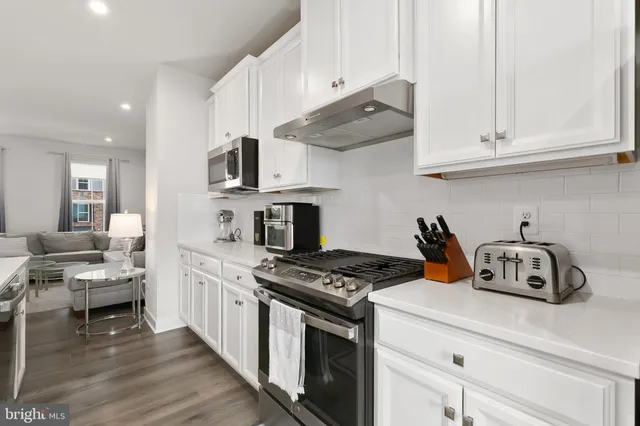 a kitchen with stainless steel appliances granite countertop a sink a stove a microwave and cabinets