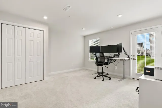 a view of a workspace with furniture and a window