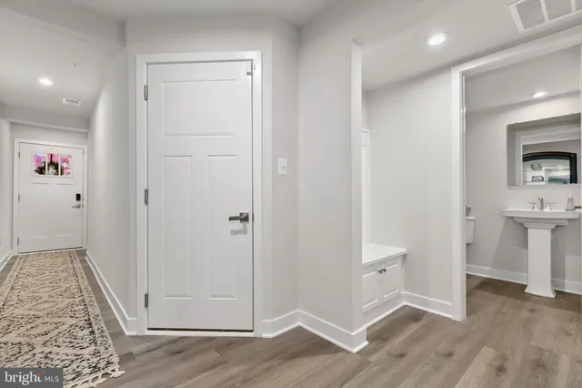 a view of a hallway with wooden floor and staircase