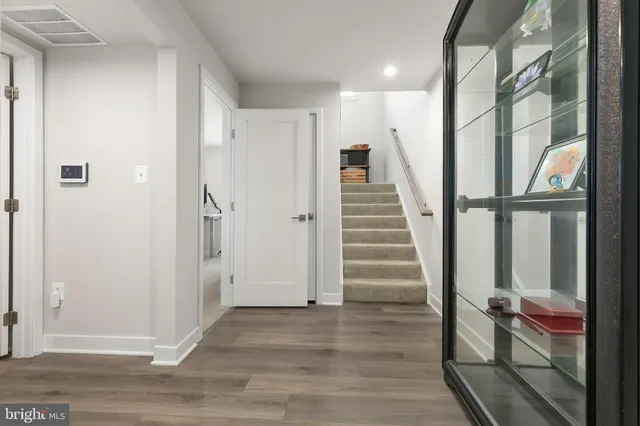 an empty room with wooden floor and a floor to ceiling window