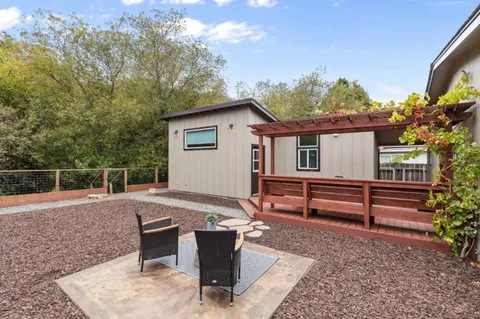 a view of a house with backyard and sitting area