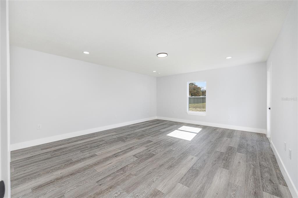 3244 Southeast 147th Lane Summerfield, FL 34491 - Photo 11 of 25 wooden floor in an empty room with a window