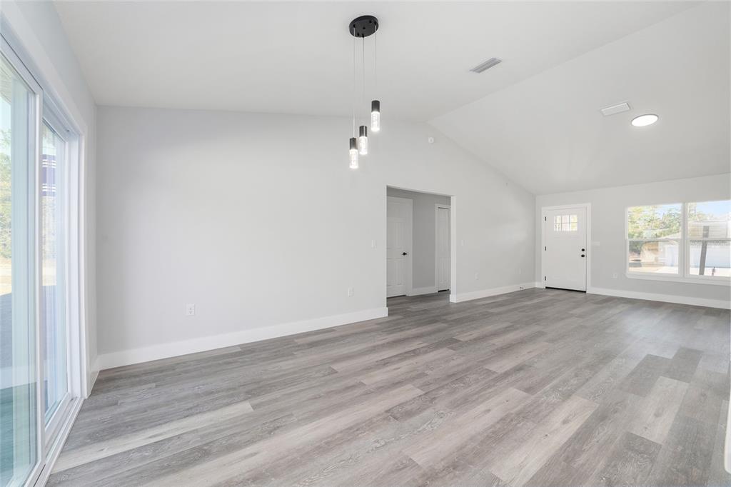 3244 Southeast 147th Lane Summerfield, FL 34491 - Photo 16 of 25 an empty room with wooden floor and windows