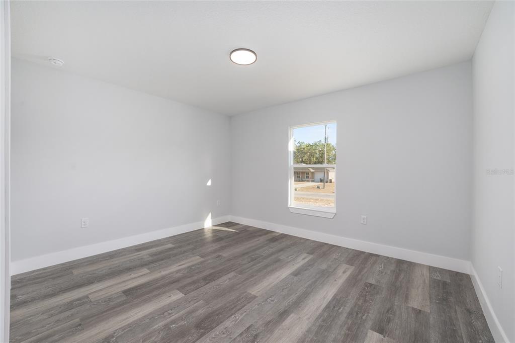 3244 Southeast 147th Lane Summerfield, FL 34491 - Photo 19 of 25 wooden floor in an empty room with a window