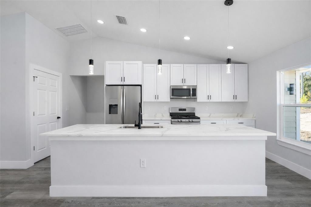 3244 Southeast 147th Lane Summerfield, FL 34491 - Photo 7 of 25 a kitchen with kitchen island a white cabinets and refrigerator