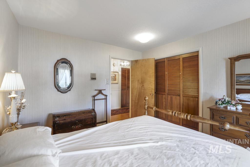 2018 Rancho Vista Drive Twin Falls, ID 83301 - Photo 28 of 50 Room featuring light-colored striped wallpaper, wood-finish bi-fold louvered closet doors, and an overhead flush-mount light fixture