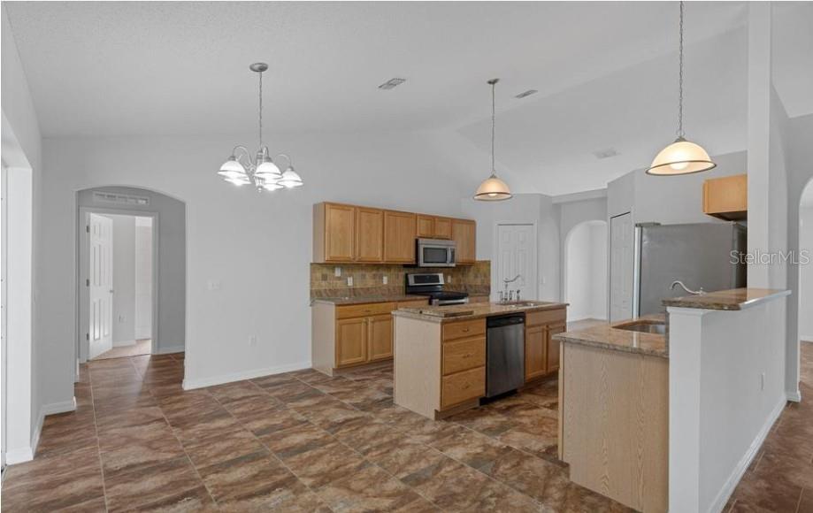 12411 Convent Garden Road Brooksville, FL 34613 - Photo 22 of 49 a kitchen that has a lot of cabinets and stainless steel appliances