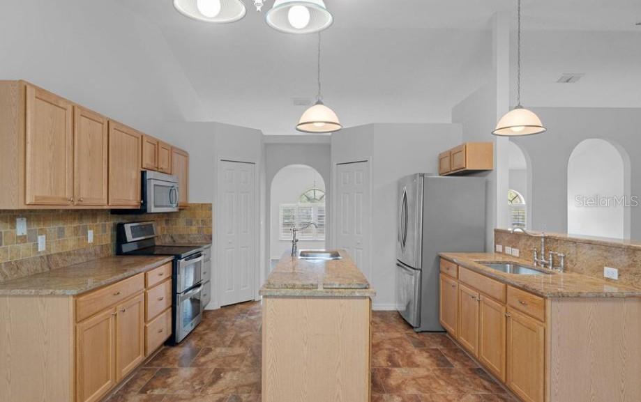 12411 Convent Garden Road Brooksville, FL 34613 - Photo 23 of 49 a kitchen with sink a microwave and cabinets