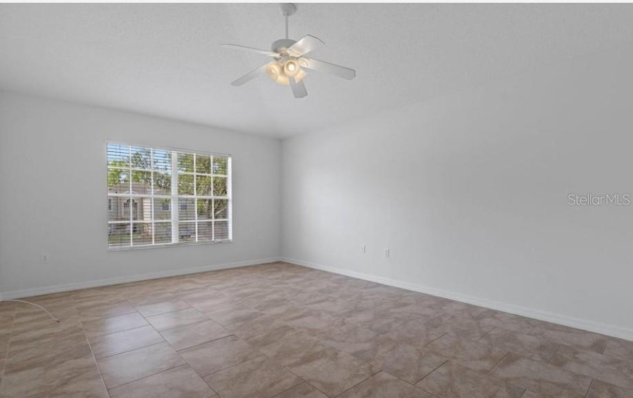 12411 Convent Garden Road Brooksville, FL 34613 - Photo 25 of 49 an empty room with chandelier fan
