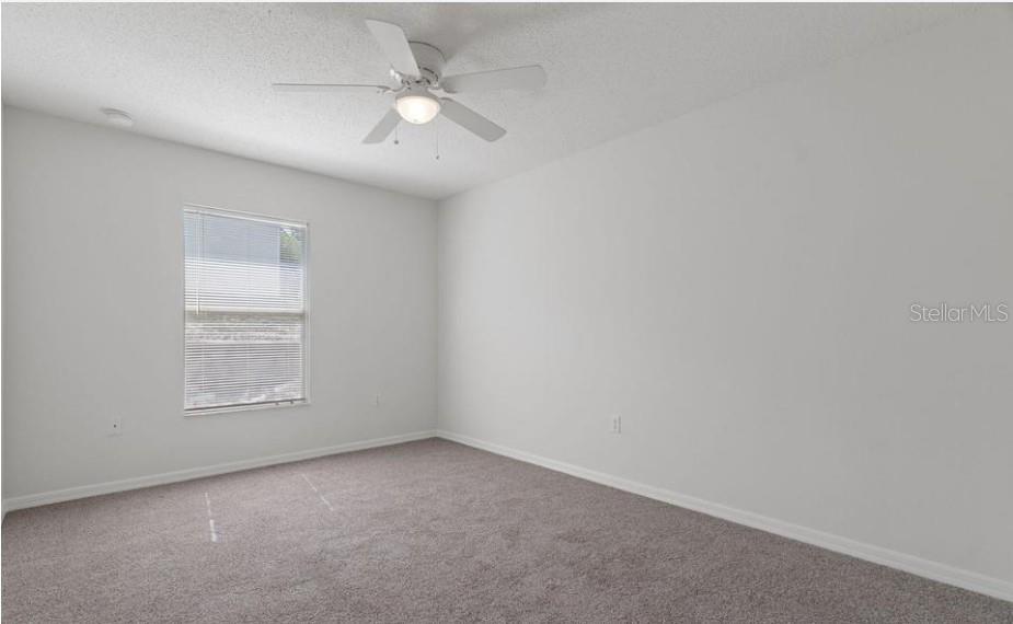 12411 Convent Garden Road Brooksville, FL 34613 - Photo 31 of 49 an empty room with a window and a fan