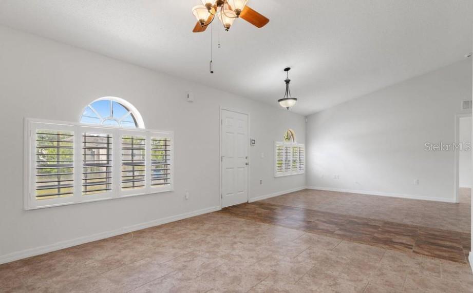 12411 Convent Garden Road Brooksville, FL 34613 - Photo 4 of 49 an empty room with chandelier fan and windows