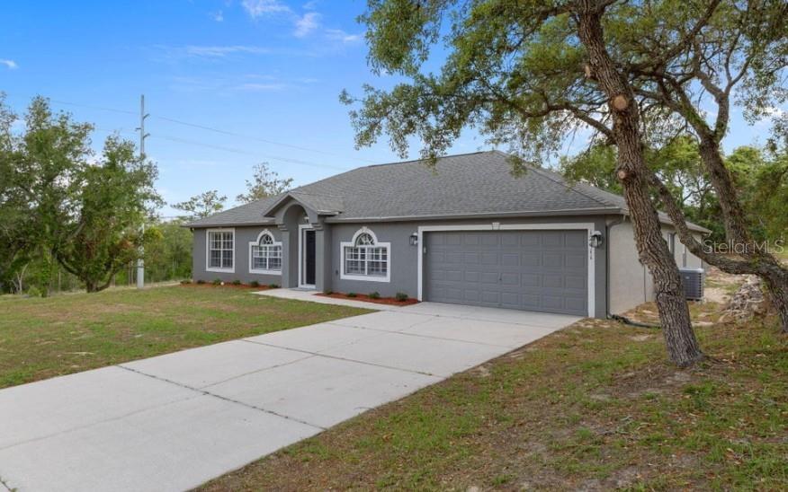 12411 Convent Garden Road Brooksville, FL 34613 - Photo 46 of 49 a front view of a house with a yard and garage