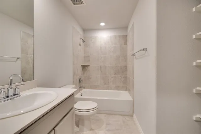 a bathroom with a granite countertop sink a toilet and shower