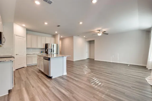 a view of kitchen with granite countertop cabinets and refrigerator