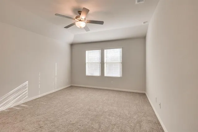 an empty room with a window and a ceiling fan