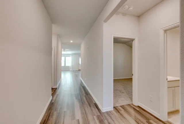 a view of a hallway with wooden floor