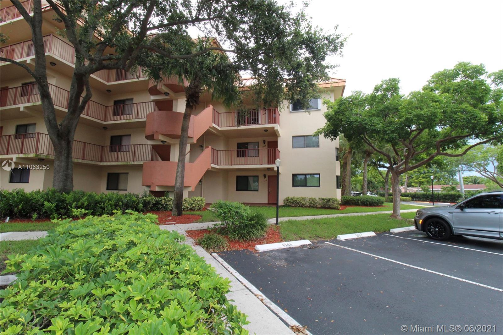 7451 Northwest 16th Street, Unit 210 Plantation, FL 33313 - Photo 2 of 16 a front view of a house with a yard and garage