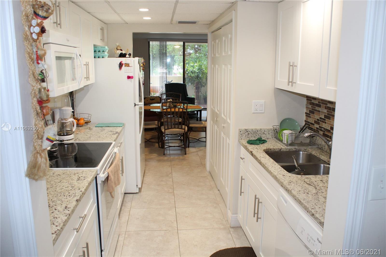 7451 Northwest 16th Street, Unit 210 Plantation, FL 33313 - Photo 6 of 16 a kitchen with stainless steel appliances kitchen island granite countertop a refrigerator and a sink