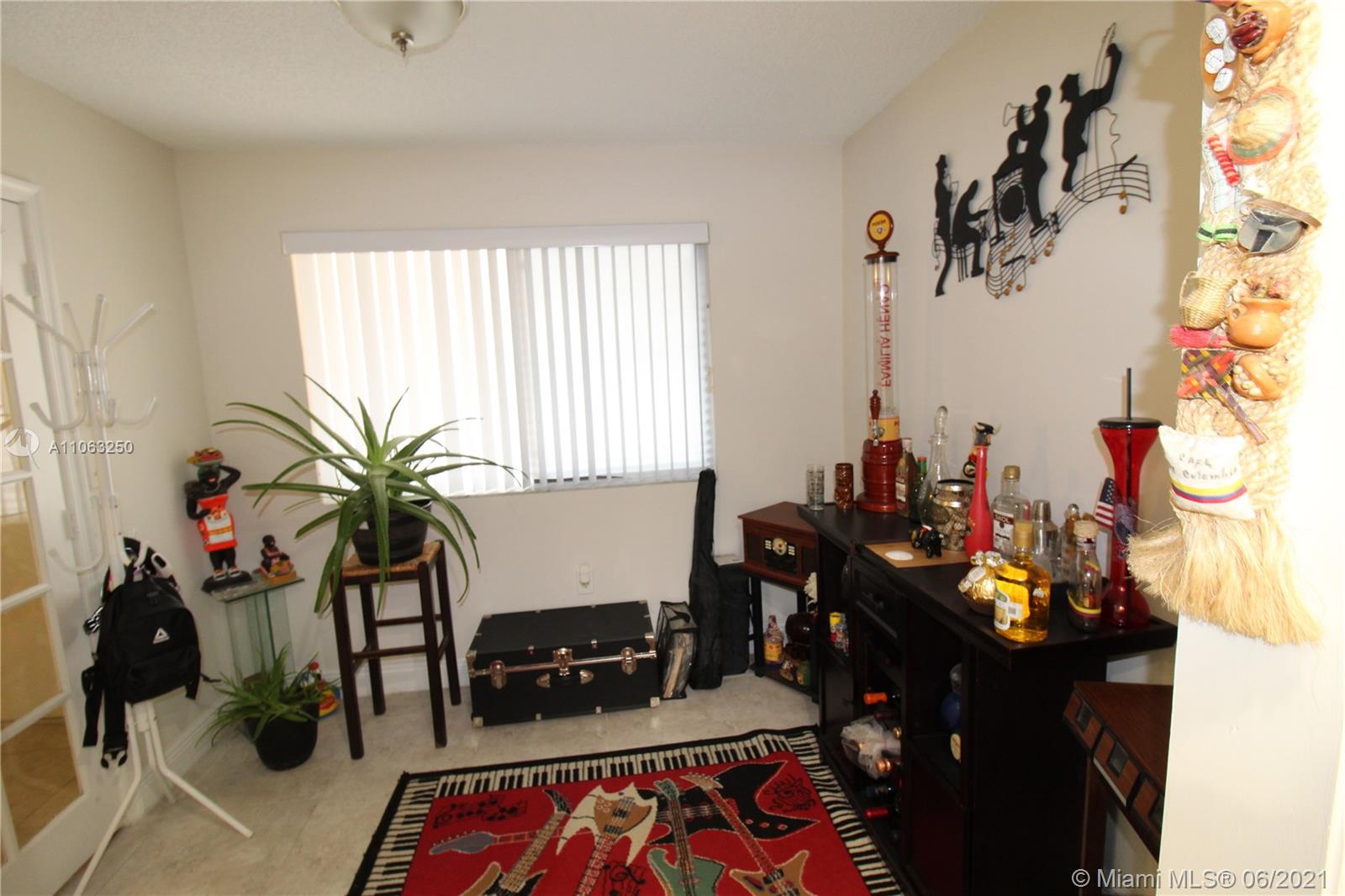7451 Northwest 16th Street, Unit 210 Plantation, FL 33313 - Photo 7 of 16 a living room with furniture and flowers
