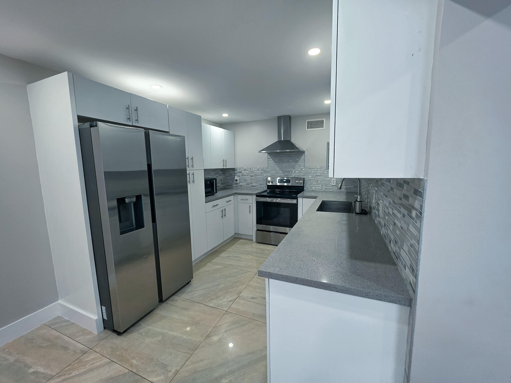 352 Johnston Street Fort Pierce, FL 34982 - Photo 10 of 28 a kitchen with stainless steel appliances granite countertop a refrigerator a stove a sink and a refrigerator