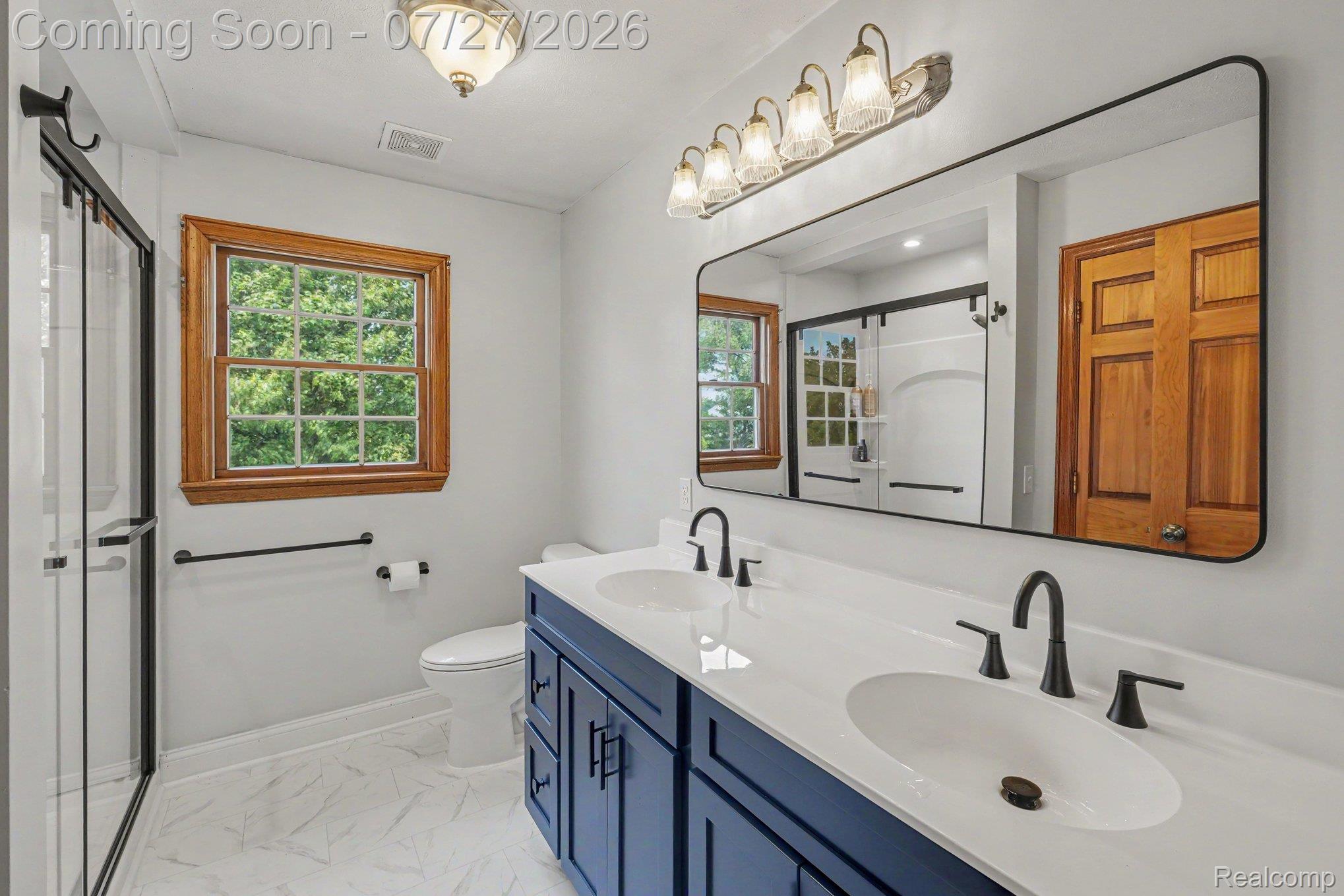 3064 South Reed Road Durand, MI 48429 - Photo 12 of 22 Dual vanity with undermount sinks, matte black fixtures, and a spacious framed mirror