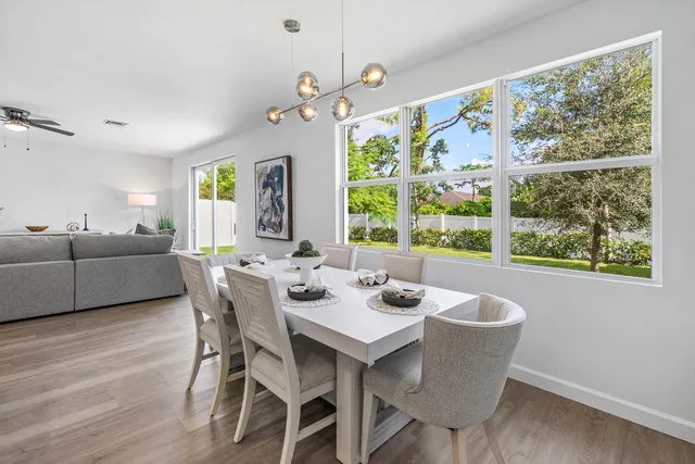 a view of a dining room with furniture a chandelier and wooden floor