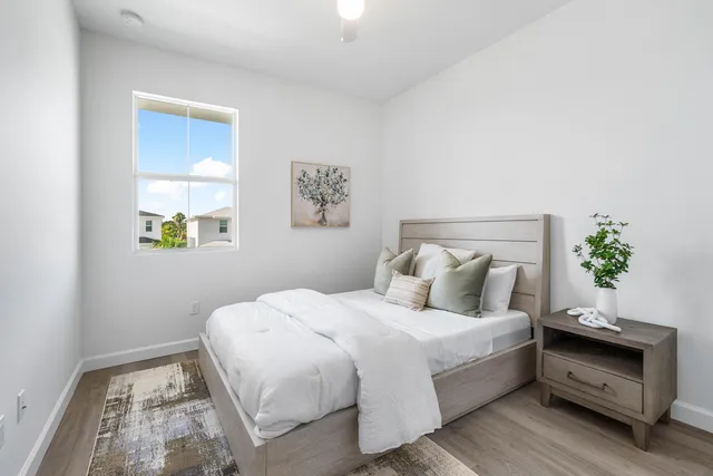 a bedroom with a bed and a potted plant